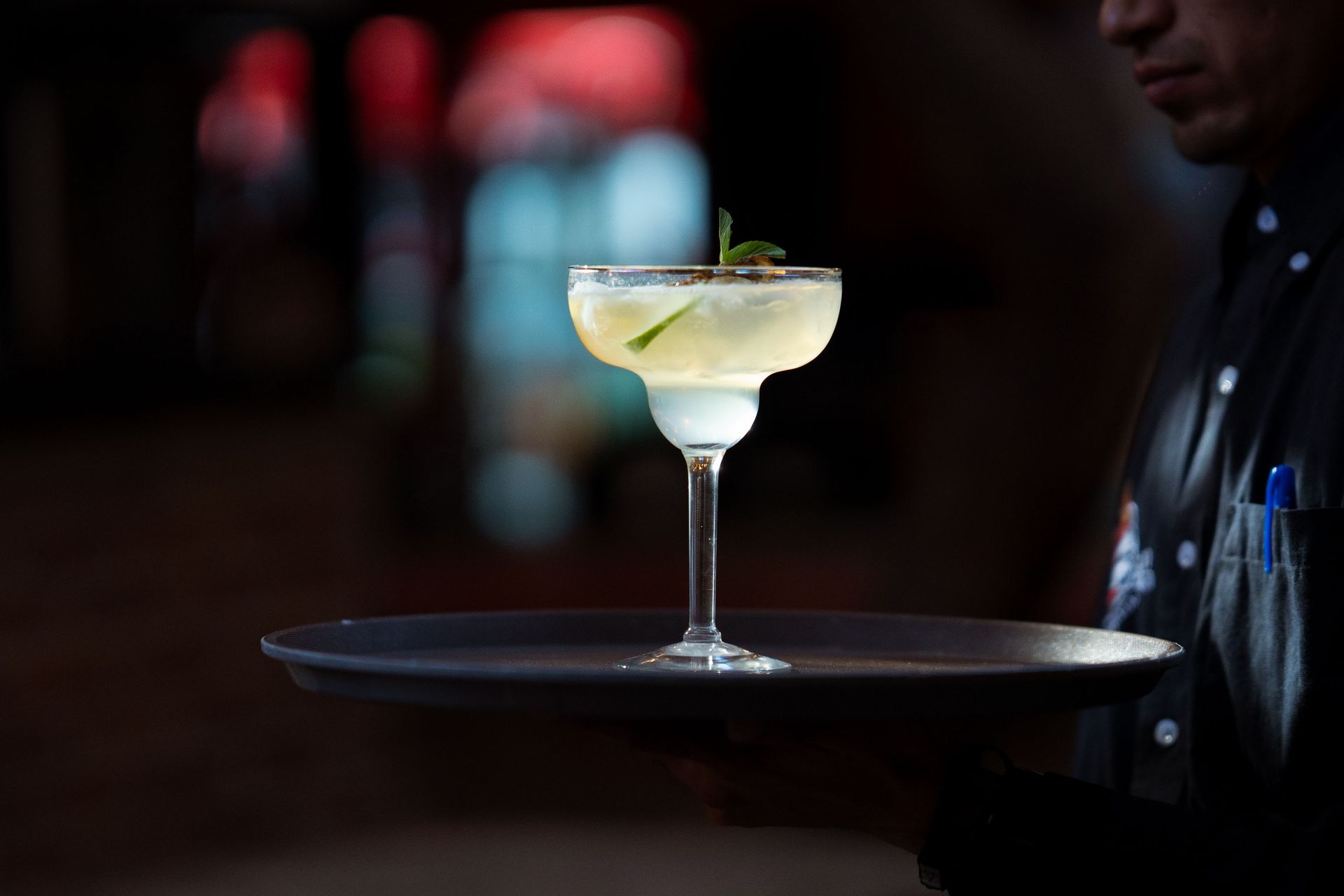 A refreshing margarita cocktail with lime wedge, served in a sophisticated setting.